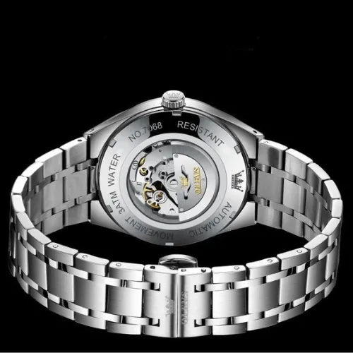 Men’s automatic timepiece with classic white dial, golden details, and transparent case back mechanism.