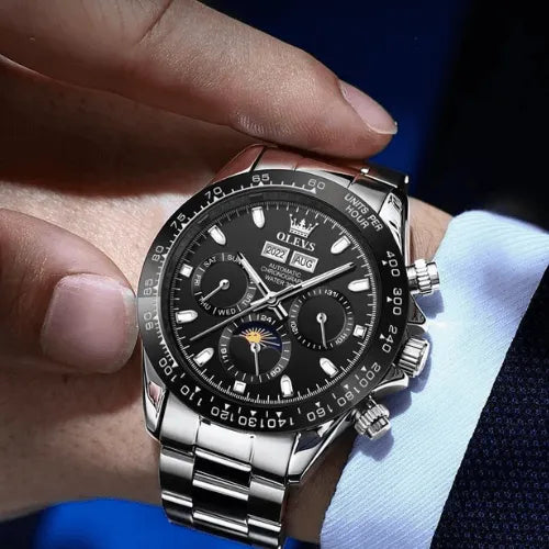 Elegant men’s wristwatch with black dial on stainless steel bracelet, showcased on the wrist in a business suit.