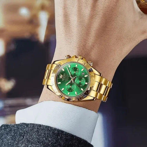 Stylish automatic men’s watch with green dial and gold strap, worn on wrist with formal suit for a luxury look.