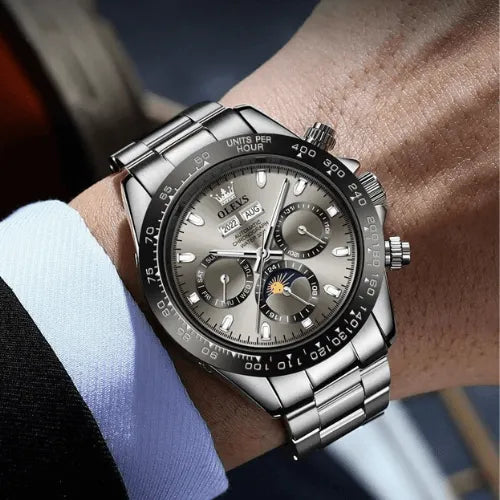 Elegant grey dial men’s watch with automatic movement and luminous hands on wrist.