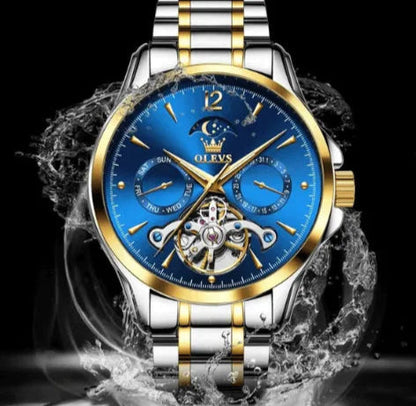 Elegant men’s automatic watch with blue dial, luminous hands, moon phase sub-dial, and stainless steel band with gold accents.