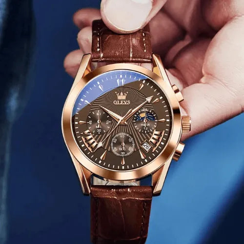 Men’s chronograph watch with rose gold casing and brown dial held by hand.