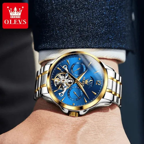 Luxury black dial automatic wristwatch with moon phase and flywheel design, worn with a suit.