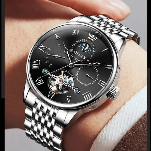 Elegant men’s automatic watch in Silver Black, shown on wrist with stainless steel strap, tourbillon movement and moon phase feature.