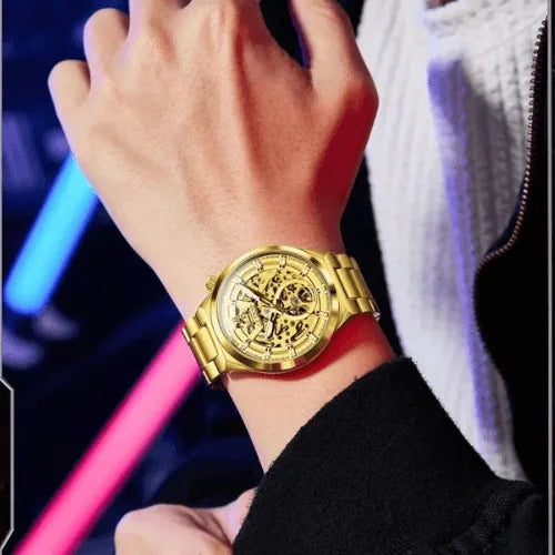 OLEVS gold skeleton automatic men’s watch worn with casual outfit, luminous details and golden stainless steel strap.