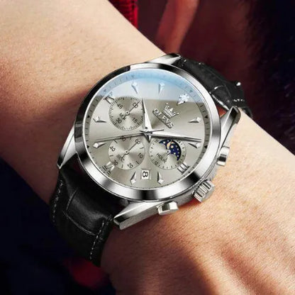 OLEVS Prestige Chronograph Black Silver watch worn on wrist, showcasing its refined dial, moon phase display, date window, and elegant black leather strap.
