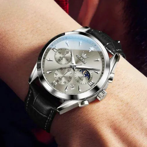 OLEVS Prestige Chronograph Black Silver watch worn on wrist, showcasing its refined dial, moon phase display, date window, and elegant black leather strap.
