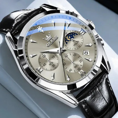 Detailed view of the OLEVS Prestige Chronograph Silver White watch showing its silver face, three chronograph counters, moon phase dial, and date display under sapphire-coated glass.