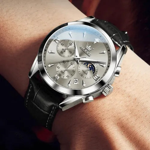 OLEVS Prestige Chronograph Silver White worn on wrist, highlighting its luminous silver dial, chronograph functions, and luxurious black leather strap with polished steel finish.