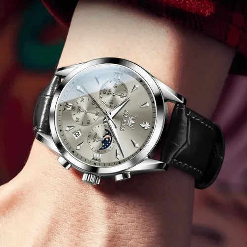 OLEVS Prestige Chronograph Silver White watch displayed on wrist, showing its refined silver dial with chronograph sub-dials, moon phase feature, and elegant black leather strap.