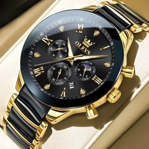 Luxury OLEVS Regal Chronograph Black and Gold watch with a black dial, gold Roman numeral markers, triple sub-dials, date display, and polished stainless-steel bracelet in black and gold tones, photographed on a beige leather surface