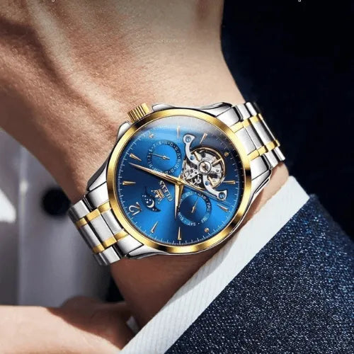 Mechanical automatic wristwatch for men with striking blue dial, skeleton movement, moon phase window, and silver-gold bracelet.