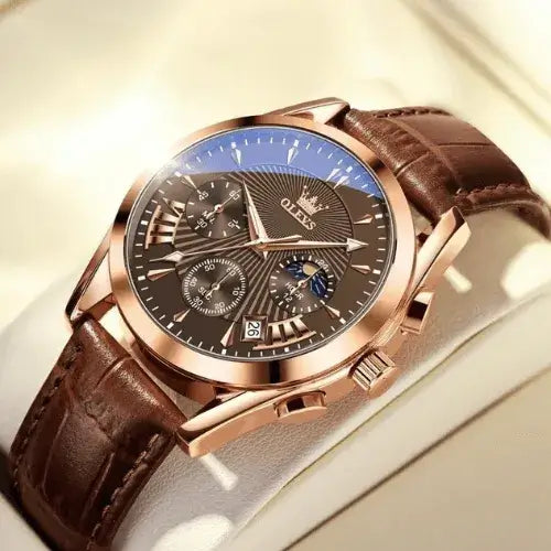 Luxury men’s chronograph watch with rose gold case, brown dial and leather strap displayed under warm light