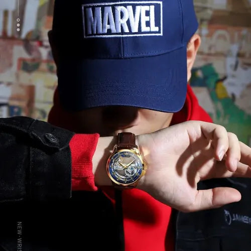 Gold skeleton men’s watch with brown leather strap and open-heart dial.